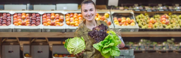 Una donna al supermercato. Bella giovane donna shopping in un supermercato e l'acquisto di verdure biologiche fresche — Foto Stock