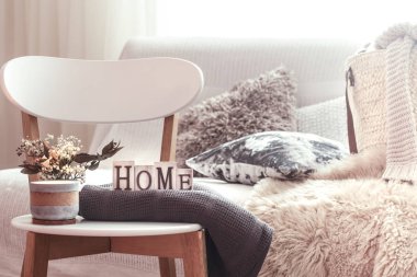 Mumlar, ahşap ev ahşap beyaz sandalye üzerinde harflerin çiçeklerle bir vazo. Kanepe ve hasır sepet içinde belgili tanımlık geçmiş yastıkları ile.