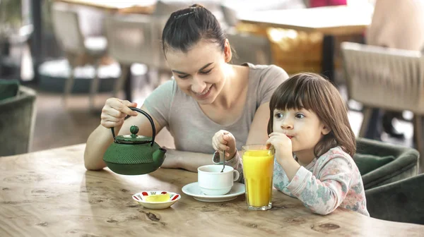 Мама с дочкой пьют чай в кафе. — стоковое фото