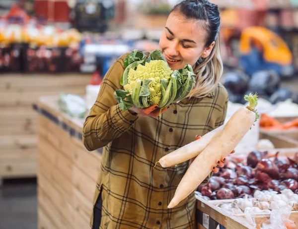 Marketteki kadın. Taze organik sebze, lahana ve turp tutan güzel genç kadın — Stok fotoğraf