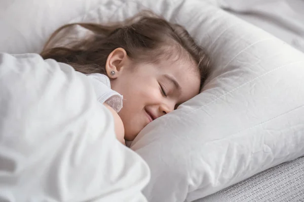 Süßes kleines Mädchen schläft süß im Bett — Stockfoto