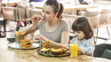 Bir kafede hızlı yemek yeme şirin kızı olan anne