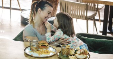 Bir kafede hızlı yemek yeme şirin kızı olan anne