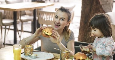 Bir kafede hızlı yemek yeme şirin kızı olan anne