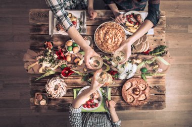 Tatil arkadaşlarınız veya aileniz şenlikli masada Tavşan eti, sebze, turta, yumurta, üstten görünüm ile.