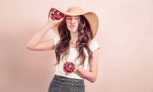Портрет девушки в летней шляпе с фруктами на цветном фоне — стоковое фото