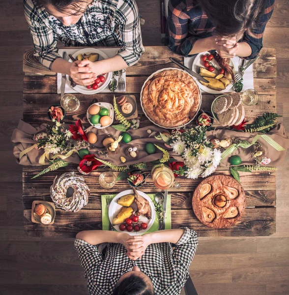 Férias amigos ou familiares na vista superior da mesa festiva. Amigos rezam em honra da Páscoa na mesa festiva — Fotografia de Stock