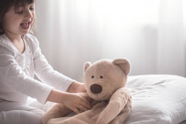 Küçük sevimli kız yatakta oynarken , uyku kavramı