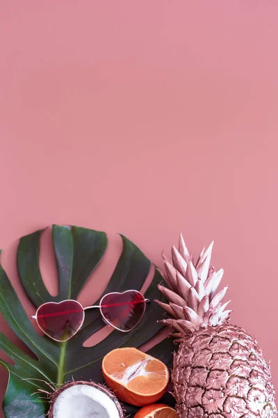 Pineapple with tropical leaf and glasses on a colored background. summer tropical concept