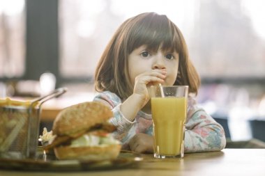 Küçük kız bir lokanta kafede yiyor