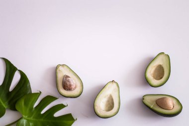 Beyaz arka planda tropikal yaprakları ile Avokado