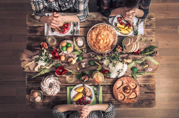 Férias amigos ou familiares na vista superior da mesa festiva. Amigos rezam em honra da Páscoa na mesa festiva — Fotografia de Stock