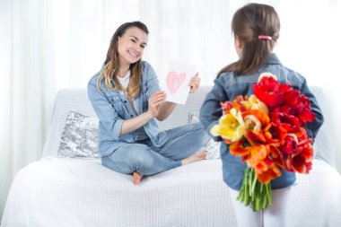 Anneler günü. Çiçekli küçük kız annesini tebrik etti
