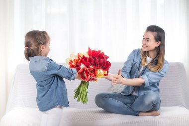 Anneler günü. Çiçekli küçük kız annesini tebrik etti