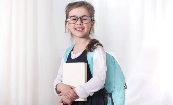 Estudiante de escuela primaria con una mochila y un libro — Foto de Stock