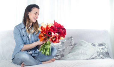 Young girl with a bouquet of tulips in the living room