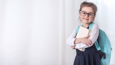 Bir sırt çantası ve bir kitap ile kız-ilkokul öğrencisi