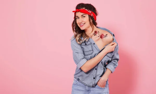 Портрет стильной девушки в джинсовой одежде на розовом фоне — стоковое фото