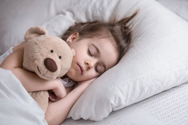 Little cute girl in bed with toy — Stock Photo, Image