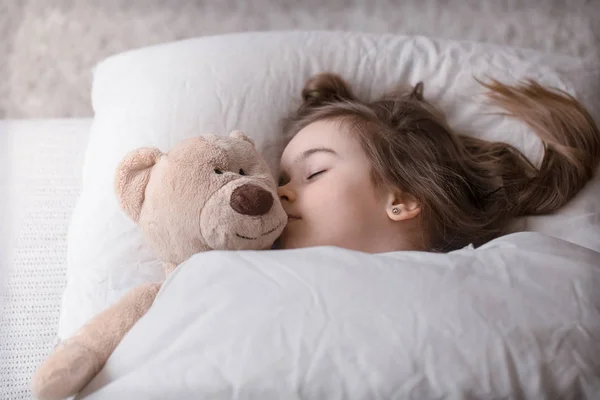 Kis aranyos lány az ágyban a játéko — Stock Fotó