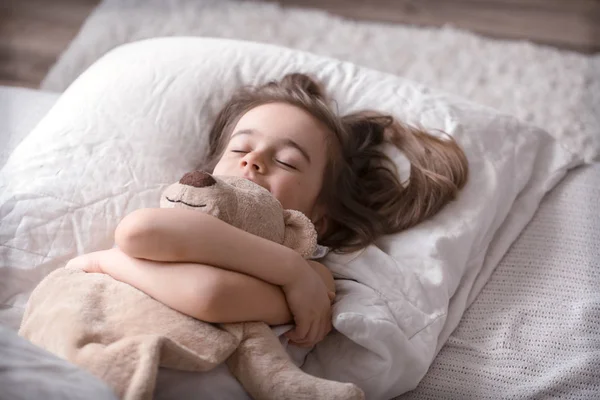 Μικρό χαριτωμένο κορίτσι στο κρεβάτι με το παιχνίδι — Φωτογραφία Αρχείου