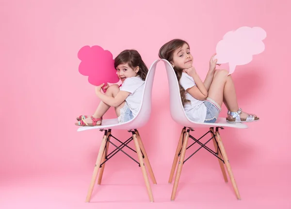 Dos chicas en un fondo de color con iconos del habla —  Fotos de Stock