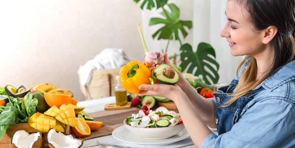 Young and happy woman eating salad at the table — Stock Photo, Image