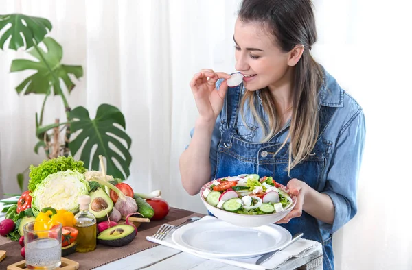 Junge und glückliche Frau isst Salat am Tisch — Stockfoto