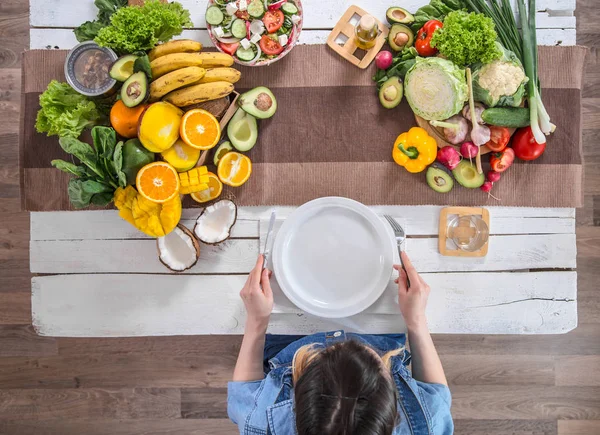 A mulher na mesa de jantar com comida orgânica, a vista do topo . — Fotografia de Stock