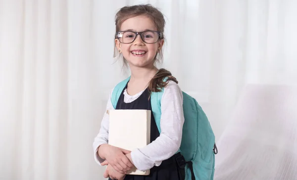 Estudiante de escuela primaria con una mochila y un libro — Foto de Stock