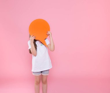 Pembe bir arka plan üzerinde bir konuşma simgesi ile sevimli küçük kız