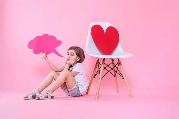 Милая маленькая девочка с иконой речи на цветном фоне — стоковое фото