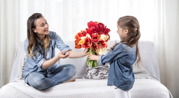 День Матери. Маленькая дочь с цветами поздравляет свою моль — стоковое фото