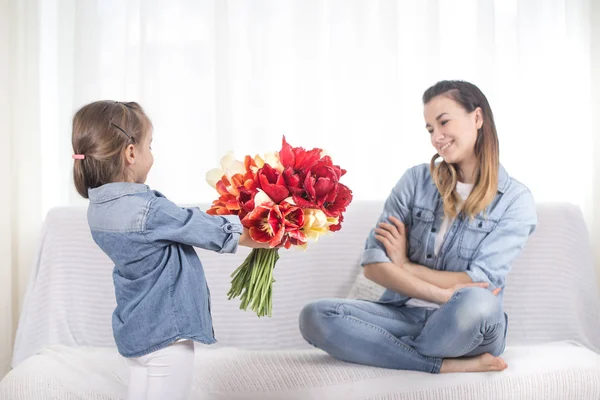 День Матери. Маленькая дочь с цветами поздравляет свою моль — стоковое фото