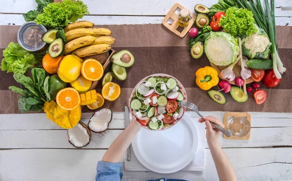 A mulher na mesa de jantar com comida orgânica, a vista de — Fotografia de Stock