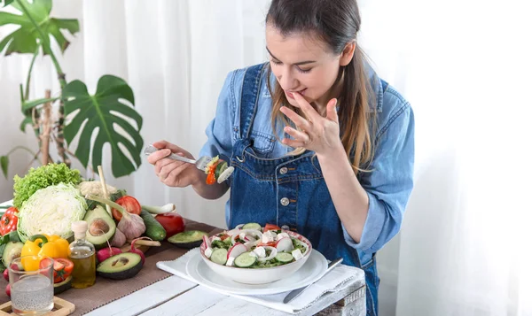 Junge und glückliche Frau isst Salat am Tisch — Stockfoto