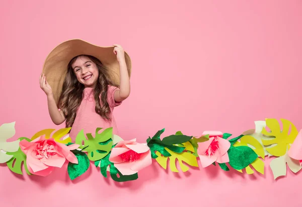 Портрет маленькой девочки в летней шляпе на розовом фоне — стоковое фото