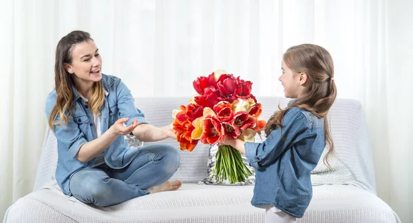 Mother's day. Little daughter with flowers congratulates her mot — Stock Photo, Image