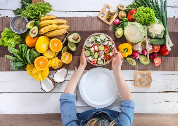 De vrouw aan de eettafel met biologisch eten, het uitzicht vanaf — Stockfoto