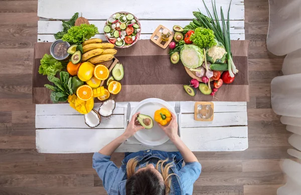 A mulher na mesa de jantar com comida orgânica, a vista de — Fotografia de Stock