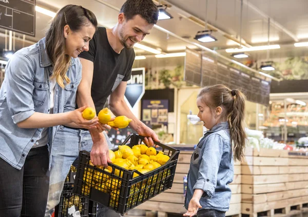 Familia eligiendo limones y frutas en el supermercado — Foto de Stock