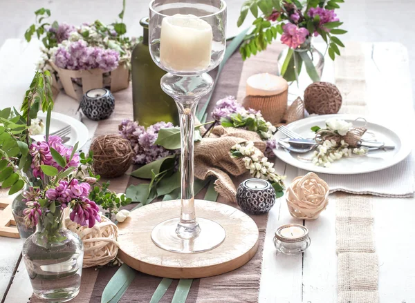 Bellamente elegante mesa decorada para vacaciones - boda o día de San Valentín con cubiertos modernos, arco, vidrio, vela y regalo —  Fotos de Stock