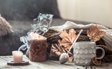 Yatakta natürmort sahnesinde rahat sonbahar sabah kahvaltısı. Buğulama fincanı sıcak kahve, pencerenin yanında duran çay. Sonbahar.