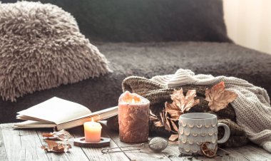 Yatakta natürmort sahnesinde rahat sonbahar sabah kahvaltısı. Buğulama fincanı sıcak kahve, pencerenin yanında duran çay. Sonbahar.