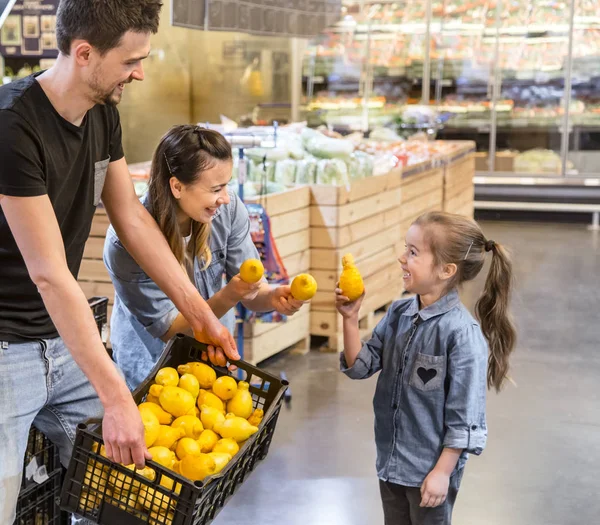 Familia eligiendo limones y frutas en el supermercado — Foto de Stock