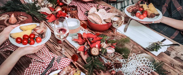 Arkadaşların elleri birlikte yiyip içiyor. Ahşap rustik masada birlikte parti yapan, toplayan, kutlayan insanların üst görünümü