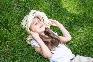 Çimenlerde yatan küçük kız. yaz saati ve güneşli gün