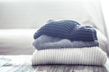 Ahşap bir masa üzerinde örme kazak yığını