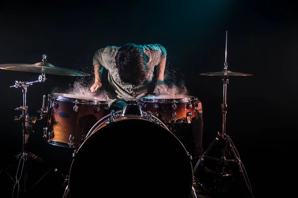 Músico tocando bateria com salpicos, fundo preto com beau — Fotografia de Stock