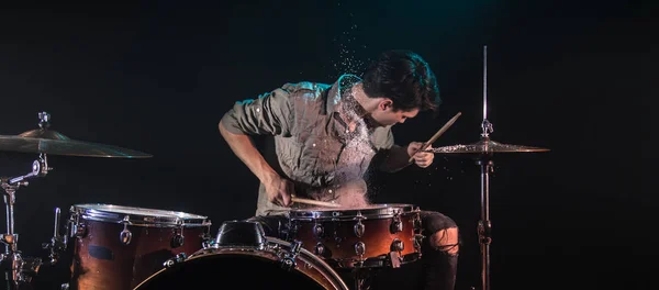 Músico tocando tambores con salpicaduras, fondo negro con beau — Foto de Stock